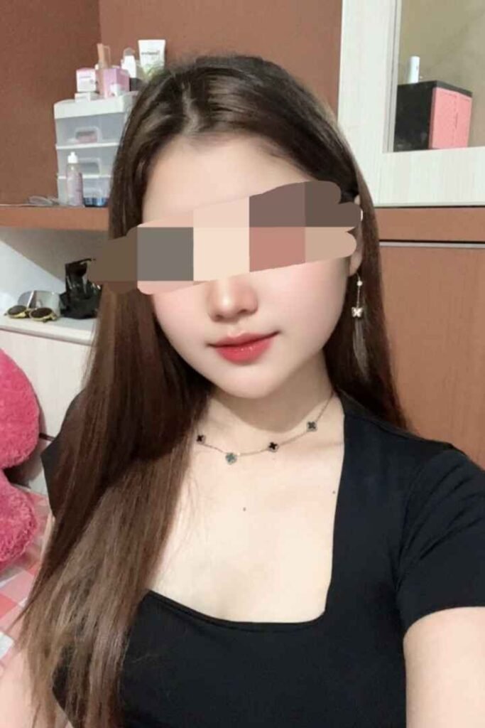 Portrait of Amina, a 22yo Malay escort in KL, wearing a black top and necklace.