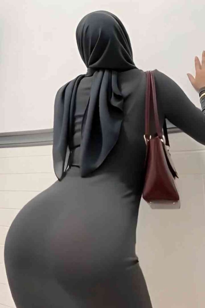 Woman in grey hijab and dress with maroon handbag